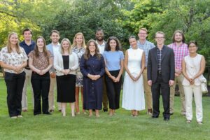 A group of young associates standing outside on a summer evening. 
